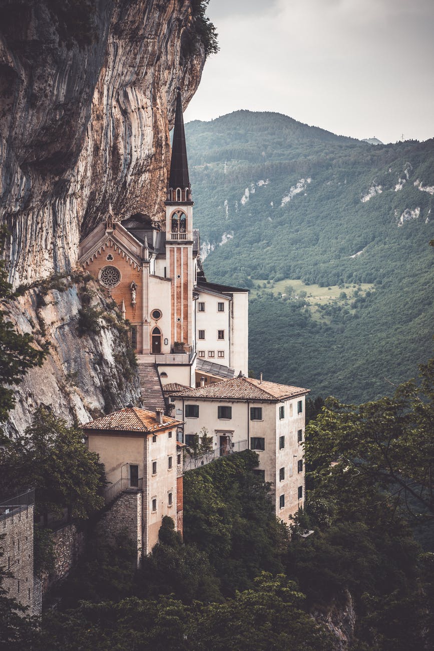 brown and white concrete building on cliff